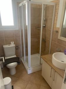 Un baño con ducha, inodoro y lavabo. en 2+1 in Cyprus Thalassa Beach Resort, en Vokolidha
