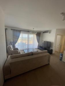 Una sala de estar con un sofá y un televisor. en 2+1 in Cyprus Thalassa Beach Resort, en Vokolidha