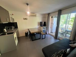 kuchnia i salon ze stołem i kanapą w obiekcie ANTINEA Joli T2 cabine piscine proche plage Richelieu cap d'Agde w Cap d'Agde