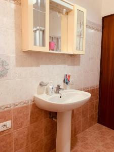 a bathroom with a white sink and a mirror at Appartamenti Il Sole Parghelia in Parghelia +55 photos