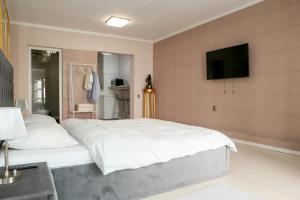 a bedroom with a large bed with a television on the wall at Azur House in Cluj-Napoca