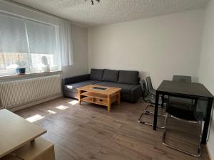 a living room with a couch and a table at Ferienwohnung mit vollausgestatteter Küche - SmartTV I Free Netflix I 24h Check in in Bielefeld