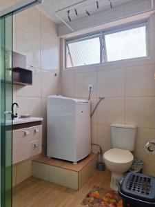 a bathroom with a toilet and a sink and a window at Joia Centro Manaus - Apartamento in Manaus +12 photos