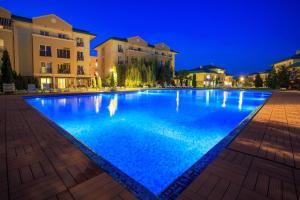 a large swimming pool at night with buildings at Studio Ama in Văleni