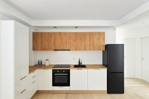 a kitchen with a black refrigerator and wooden cabinets at Studio Ama in Văleni