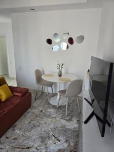 a dining room with a white table and chairs at Studio Ama in Văleni +1 photo