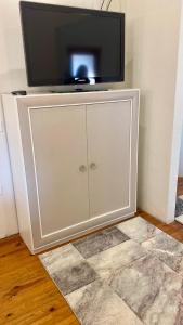 Un mueble blanco con un televisor encima. en Bella Villa, en Villalpando