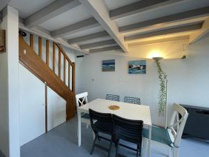 a dining room with a white table and chairs at T2 avec Mezzanine, Piscine, Parking, Animaux admis - FR-1-379-131 in Vieux-Boucau-les-Bains