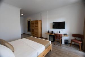 a bedroom with a bed and a desk and a television at The Rest Port Village in Edirne