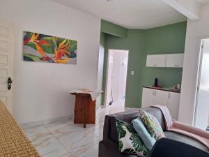 a living room with a couch and a kitchen at Joia Centro Manaus - Apartamento in Manaus
