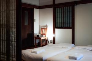 a bedroom with two beds and a chair and a desk at EXP Atelier in Fujinomiya
