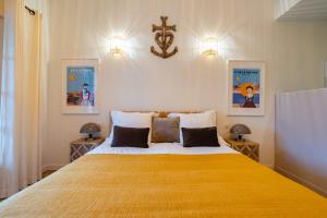 a bedroom with a large bed with a yellow blanket at Mas du Couvin, maison d'hôtes en Camargue in Saintes-Maries-de-la-Mer