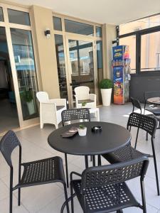 czarny stół i krzesła przed budynkiem w obiekcie Hotel Adria Mare w Rimini +28 zdjęć