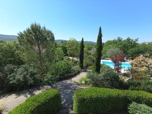 a garden with a swimming pool and trees and bushes at Gîte Le Mas de Molines in Vogüé