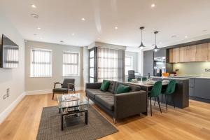 雷丁Bond House by Celador Apartments的客厅以及带沙发和桌子的厨房。