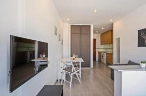 eine Küche und ein Wohnzimmer mit einem großen TV an der Wand in der Unterkunft Cala de Mijas Beach & Golf Studio in La Cala de Mijas