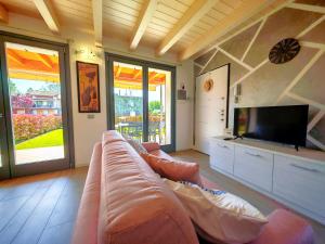 a living room with a couch and a flat screen tv at SG Luxury - Crystal Bay Apartment in Ronchi