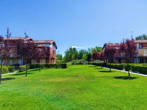 a large lawn in front of two buildings at SG Luxury - Crystal Bay Apartment in Ronchi