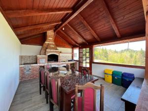 a dining room with a table and a fireplace at Căsuța din Pădure in Colibiţa