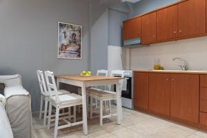 a kitchen with a table and chairs and a sink at Stay & Smile apartments in Kallithea Halkidikis +5 photos