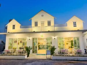 a large white house with chairs in front of it at TheHill Resort เลาขวัญ in Ban Nong Masang