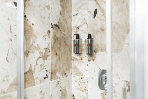 a bathroom with a shower with two bottles on the wall at Maison dei Greci in Rome