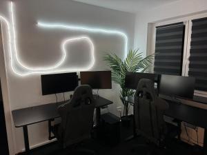 a room with two desks and two chairs with monitors at World of Esport in Bayreuth