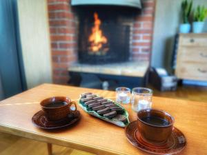 two cups of coffee and cookies on a table with a fireplace at VillaVasa Original in Transtrand