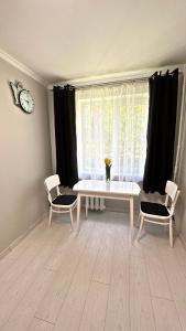 a living room with a table and two chairs and a window at Parkside Apartment Odesa in Odesa