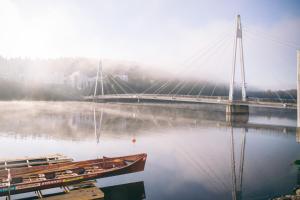 a bridge over a river with a boat in the water at Finlandia Hotel Alba in Jyväskylä