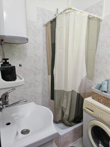 a bathroom with a sink and a shower curtain at Vila Fruškogorski Mir in Velika Remeta