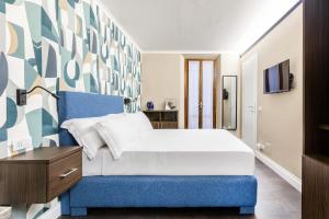 a bedroom with a bed with a blue headboard at Maison dei Greci in Rome