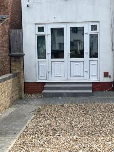 a white building with two doors on the side of it at Luxury Studio in Wembley in Wembley