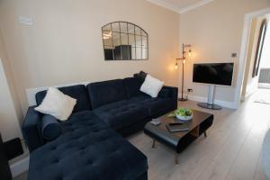 a living room with a blue couch and a coffee table at The White House near Edinburgh in Bathgate