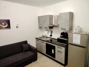 a kitchen with a couch and a stove and a refrigerator at Hotel Romagna in Cesena