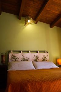 ein Bett mit zwei Kissen und einer Lampe darüber in der Unterkunft Pimpioxelli in Quartucciu