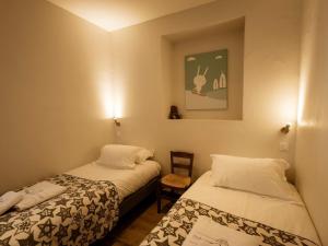 Una habitación con dos camas y una silla dentro. en Charmant appartement 4 pièces, 6 pers, balcon Sud-Ouest, centre Valloire, proche pistes et commerces - FR-1-263-361, en Valloire