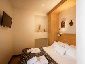 1 dormitorio con 1 cama con almohadas blancas y TV en Appartement au cœur de Valloire, 6 pers, 3 chambres, balcon, proche ski et commerces - FR-1-263-363, en Valloire