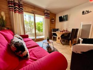 un salon avec un canapé rouge et une table dans l'établissement Superbe appartement 48m² avec terrasse, centre village, parking, proche ski-bus, non-fumeur - FR-1-624-46, à Samoëns