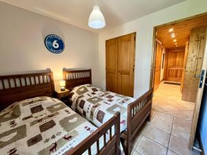 - une chambre avec 2 lits jumeaux et un couloir dans l'établissement Superbe appartement 48m² avec terrasse, centre village, parking, proche ski-bus, non-fumeur - FR-1-624-46, à Samoëns