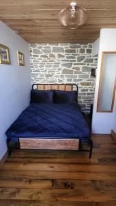 a bed in a room with a stone wall at Ty Taf- 2 Bed Cottage with Easy Transport Links to Cardiff in Cardiff
