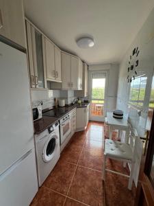 a kitchen with a washer and dryer in it at Noja. Piso en noja a 5 minutos de la playa de Ris in Noja