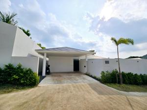 a white building with a palm tree in front of it at Private villa near beach Koh Samui in Koh Samui