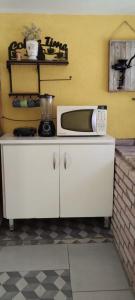 a microwave sitting on top of a kitchen counter at Sitio Oliveira Ibiuna in Ibiúna