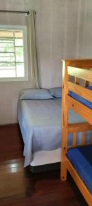 a small bedroom with a bunk bed and a window at Sitio Oliveira Ibiuna in Ibiúna