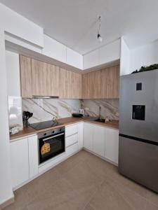a kitchen with white cabinets and stainless steel appliances at AURORA Apartment Shëngjin Kune in Shëngjin