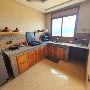 a kitchen with a counter and a sink and a window at tamazirt surf in Agadir