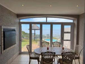 a dining room with a table and chairs on a patio at 3 Bedroom Villa in Pinnacle Point Estate in Mossel Bay