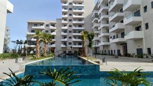 a swimming pool in front of a building at Studio Zen vue sur mer in Aïn Harrouda