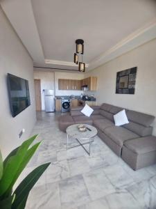 a living room with a couch and a table at Studio Zen vue sur mer in Aïn Harrouda